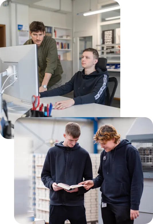 Zwei Mitarbeiter schauen auf einen Computer Bildschirm und zwei Mitarbeiter schauen in ein Buch